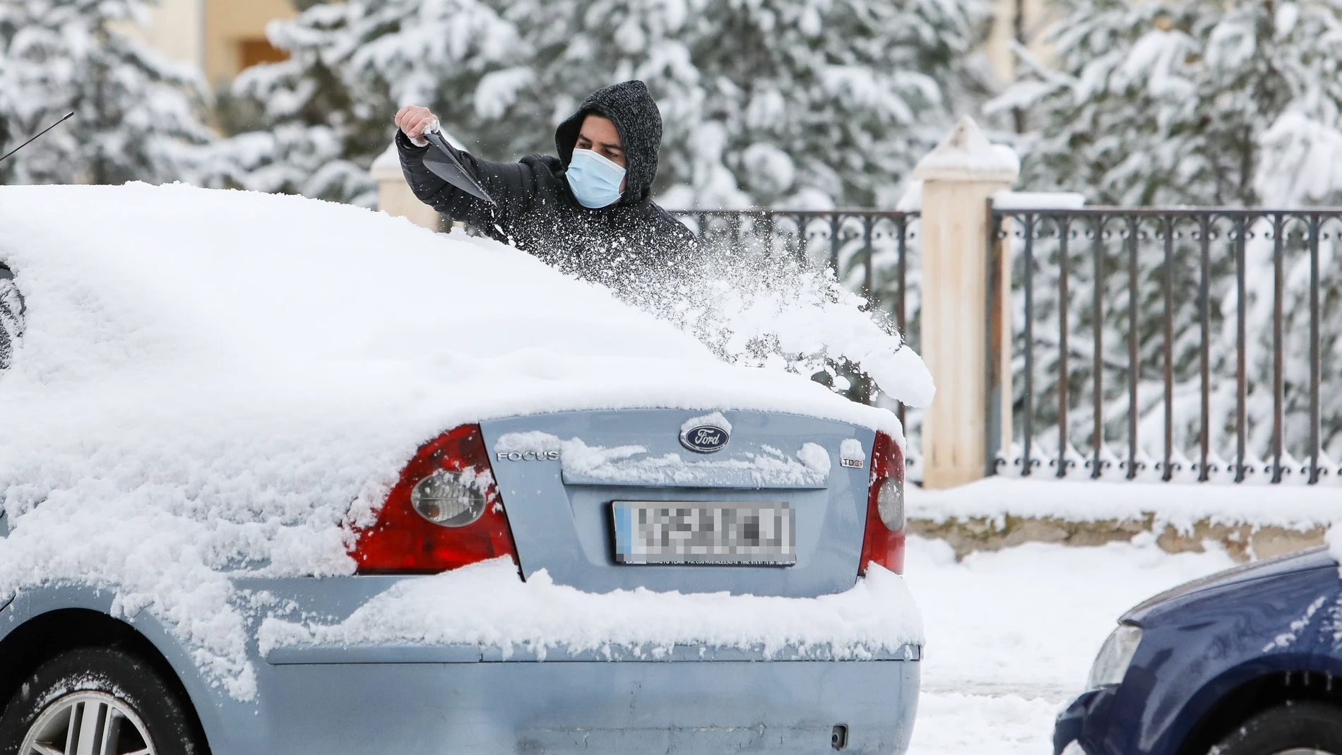 Un hombre quita la nieve de su coche tras el paso de la borrasca Filomena en Teruel, en Aragón (España) a 8 de enero de 2021. Javier Escriche / Europa Press