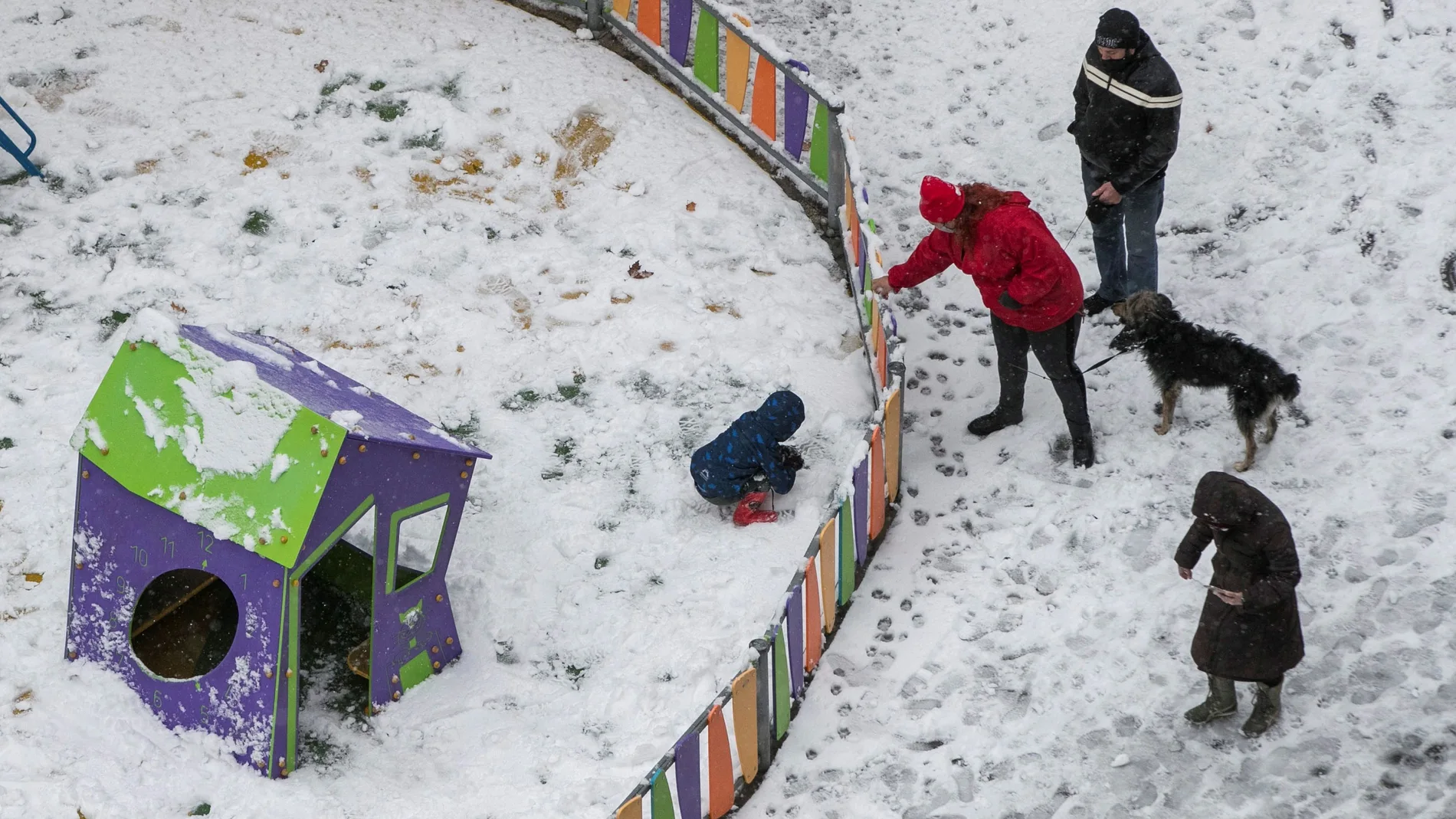 Una familia juega con la nieve en un parque infantil de Zaragoza