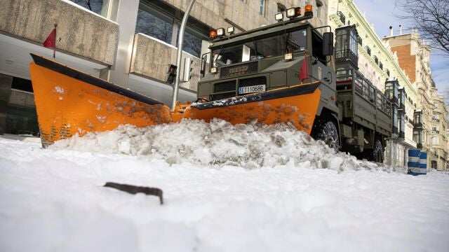 Miembros de la a Unidad Militar de Emergencias (UME) ayudados de una máquina quitanieves en el Paseo de la Castellana en Madrid