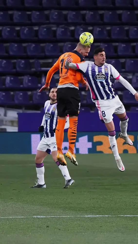 El centrocampista del Valencia Uros Racic (i) cabecea un balón ante Kike, del Real Valladolid, durante el partido de Liga en Primera División que disputan esta noche en el estadio José Zorrilla. EFE/R. García