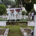 Trabajadores funerarios transporta un féretro en Indonesia