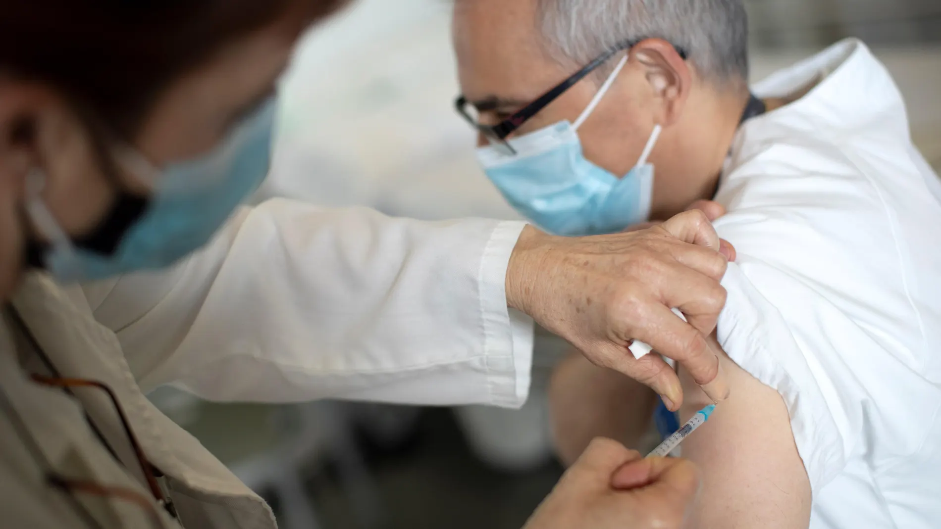 na enfermera del Hospital Sant Pau de Barcelona inyecta la vacuna de Covid-19 a un compañero
