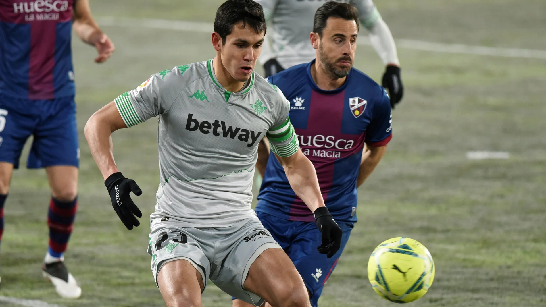 El defensa de la SD Huesca Pedro López (d) lucha con el argelino Aissa Mandi, del Real Betis, durante el partido de la jornada 18 de Liga en Primera División que se juega hoy lunes en El Alcoraz, en Huesca. EFE/JAVIER BLASCO