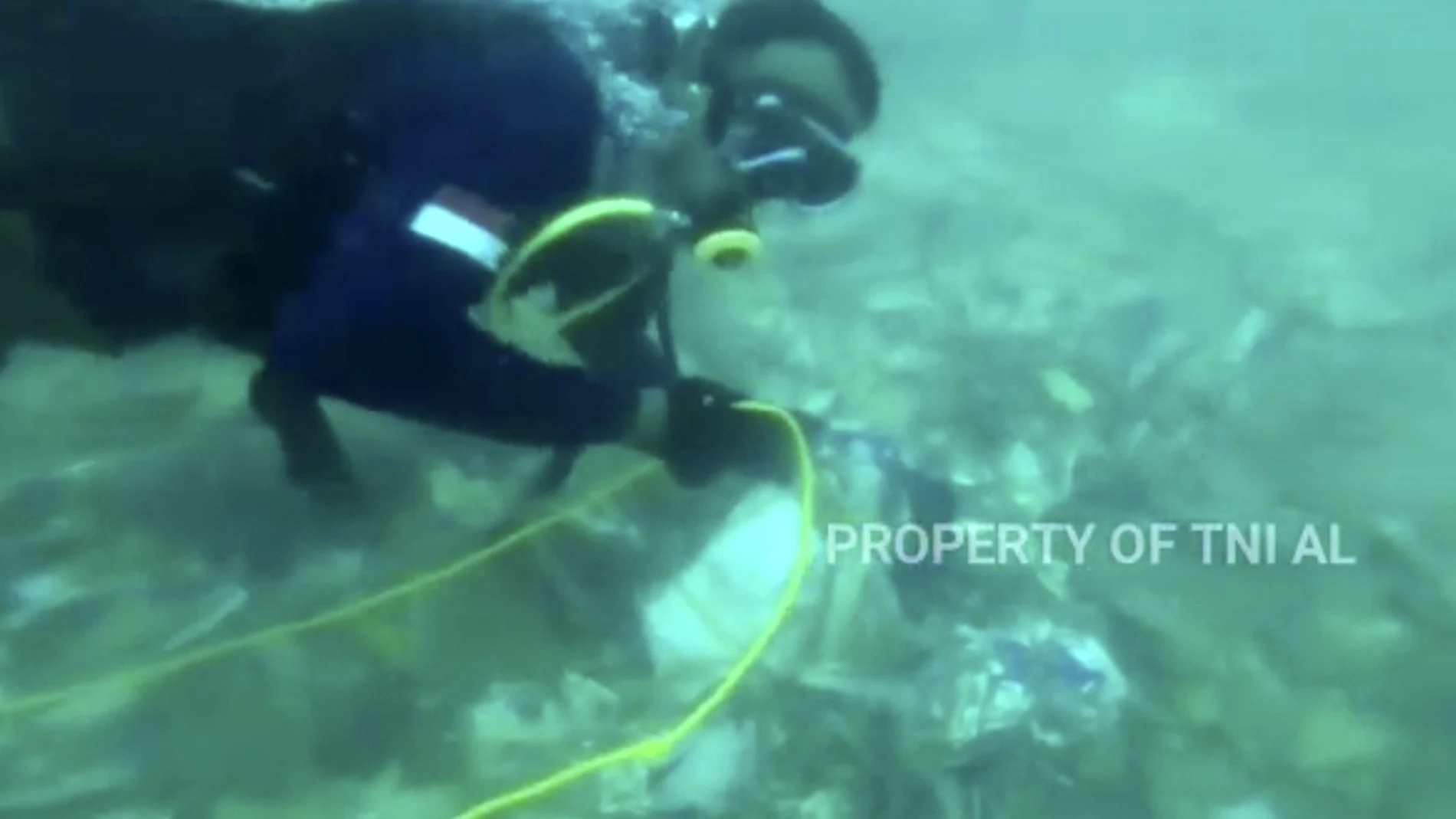 Imagen de un vídeo en el que se ve a los buzos recuperando escombros esparcidos en el fondo del mar en el mar de Java