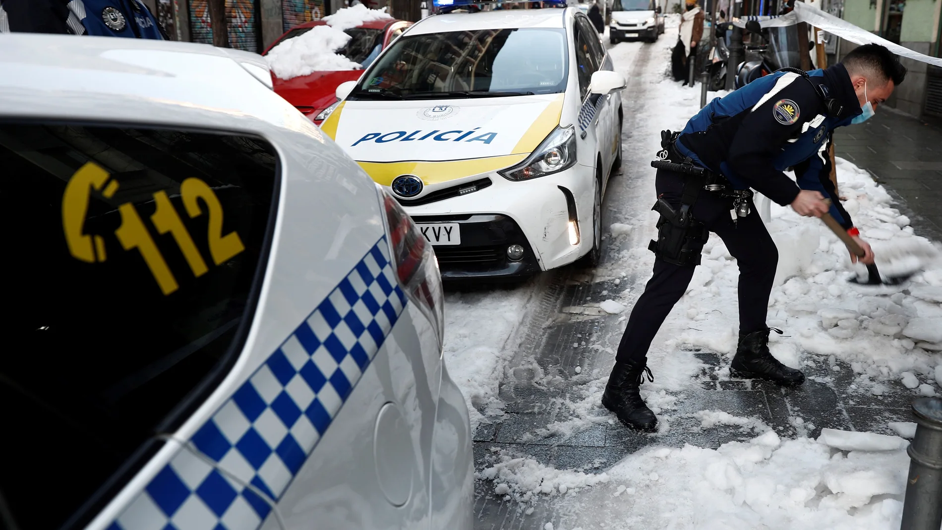 La Policía Municipal retira nieve de la calzada en una calle céntrica de Madrid