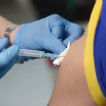 Un enfermero vacuna a un trabajador sanitario en las instalaciones del Hospital Enfermera Isabel Zendal, en Madrid, (España)