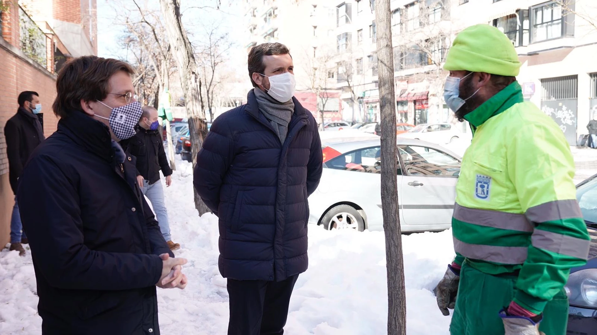 El líder del PP Pablo Casado y el alcalde de Madrid, Martínez Almeida conversan con un operario que trabaja en las labores de limpieza de la nieve