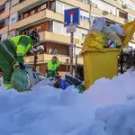 Operarios del servicio de limpieza retiran los cubos de basura de las calles de Madrid tras reiniciarse ayer el servicio de recogida suspendido tras el paso de la borrasca Filomena.