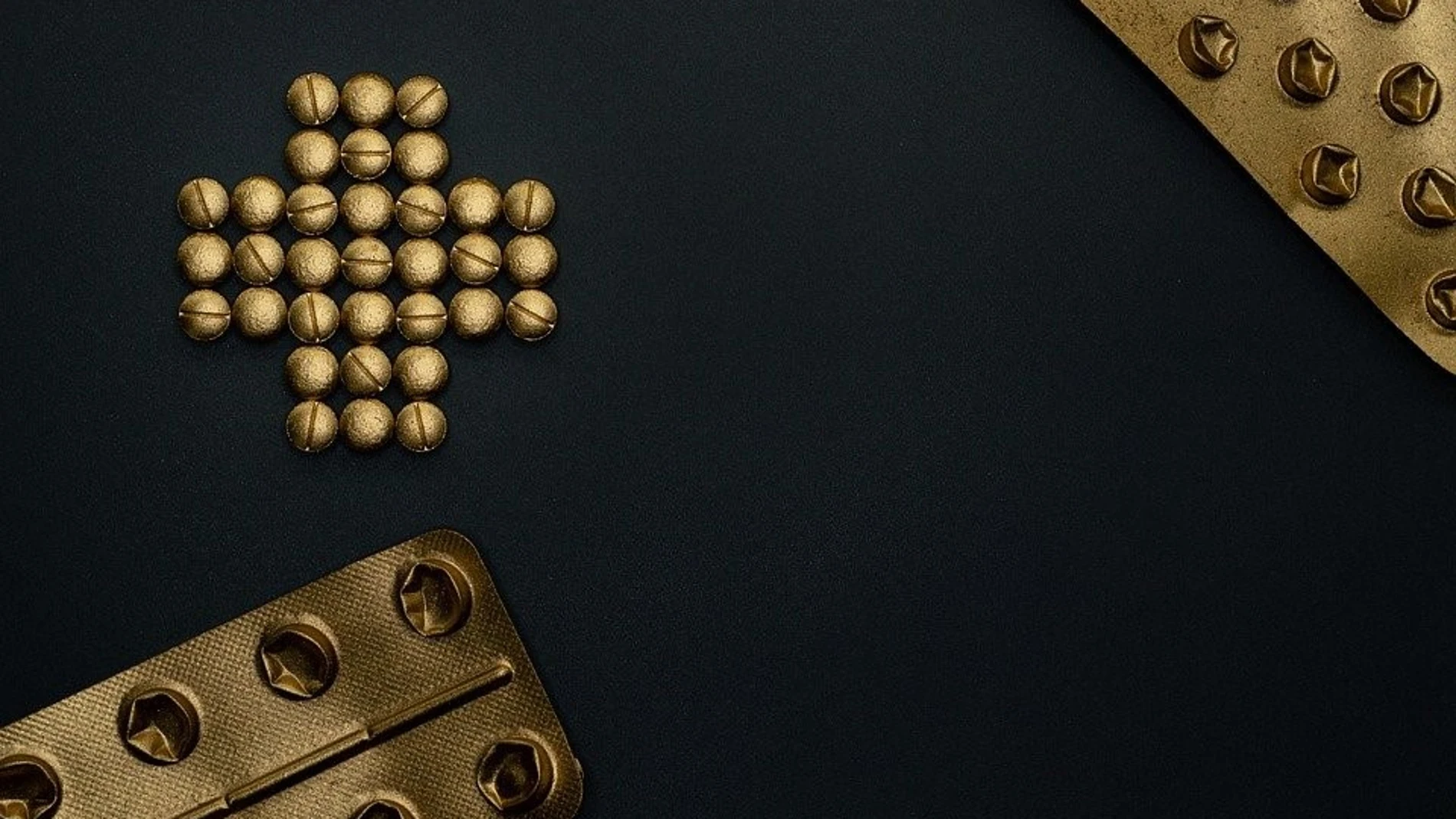 Fotografía de stock de unas pastillas doradas ordenadas en forma de cruz
