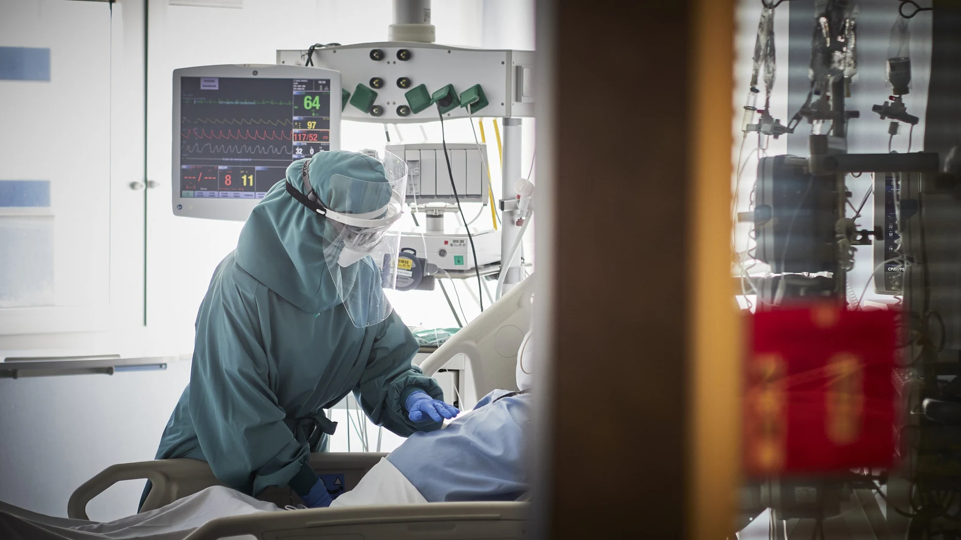 Un trabajador sanitario atiende a un paciente en una camilla de la UCI de la Clínica Universidad de Navarra, en Pamplona, Navarra, (España), a 10 de noviembre de 2020.
