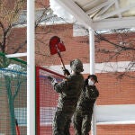 Dos militares de la Unidad Militar de Emergencias (UME) colabora en la retirada de nieve y hielo en las inmediaciones del colegio Fuente de la Villa tras la gran nevada provocada por la borrasca 'Filomena', en Valdemoro, Madrid