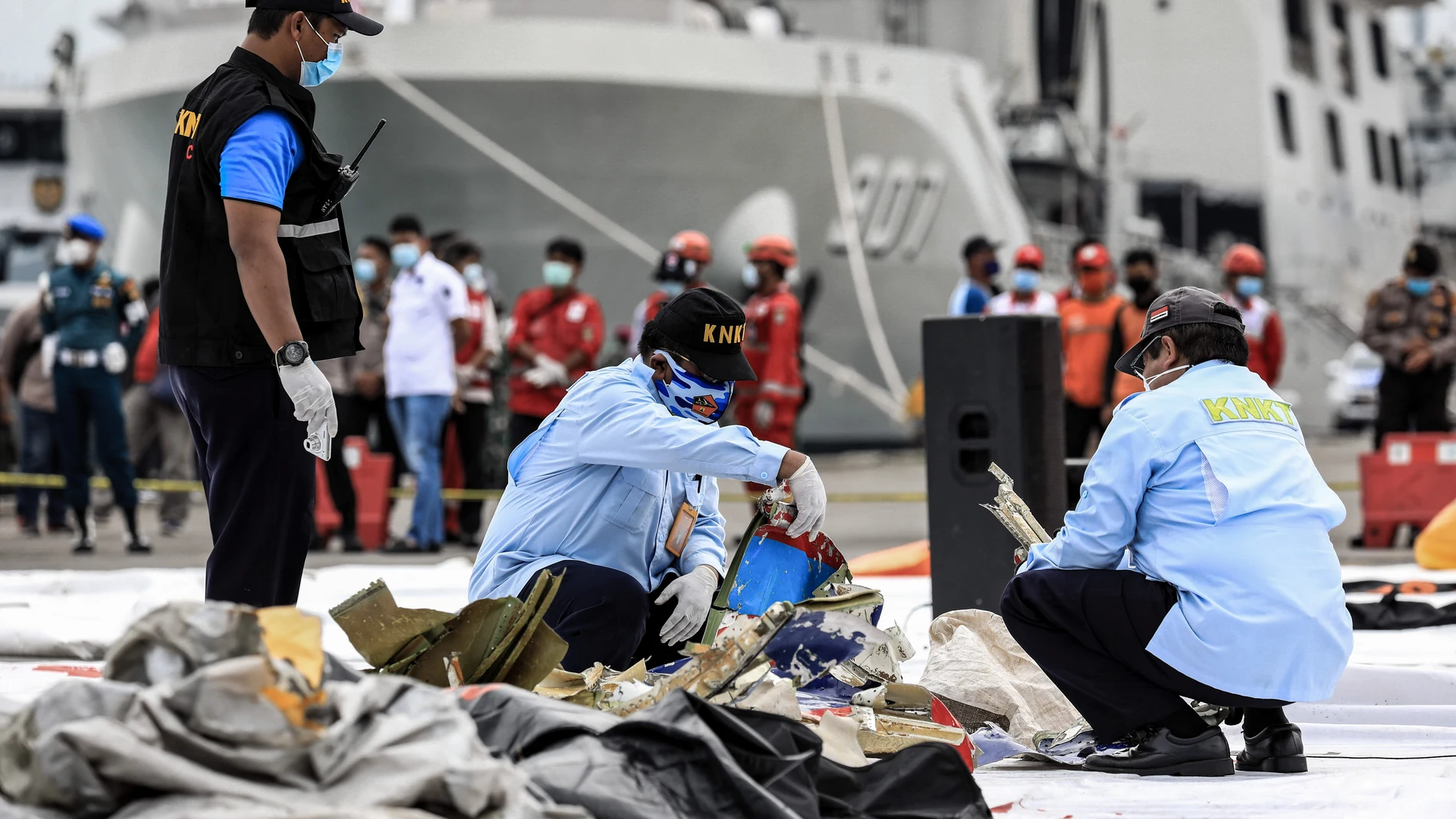 FILED - 10 January 2021, Indonesia, Jakarta: National Transportation Safety Committee and Disaster Victim Identification (DVI) police officers look through a bag of suspected debris near the crash site of the Sriwijaya Air flight SJ182 at Tanjung Priok port following the crash of a Boeing 737-500 passenger plane with 62 people on board. Photo: Risa Krisadhi/SOPA Images via ZUMA Wire/dpaRisa Krisadhi/SOPA Images via ZU / DPA10/01/2021 ONLY FOR USE IN SPAIN