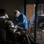 Personal sanitario administra la vacuna a una mujer en una residencia de Barcelona