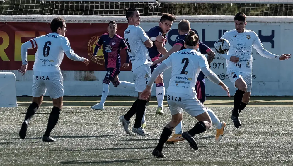 SANTA EULALIA (IBIZA) 16/01/2021.- El jugador del Peña Deportiva Pablo Pomar (c-i) intenta evitar el disparo de Zalazar (c-d), del Real Valladolid, durante su partido de dieciseisávos de final de la Copa del Rey de fútbol disputado este sábado en el Estadio Municipal de la localidad ibicenca de Santa Eulalia. EFE/Sergio G. Cañizares