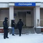 Un aliado del líder opositor ruso Alexei Navalni, acompañado por agentes de policía, entra a la comisaría donde se encuentra detenido Navalni