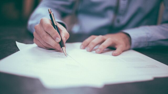 Una persona firma un contrato