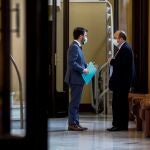 El vicepresidente del Govern con funciones de Presidente, Pere Aragonés (i) habla con el presidente del grupo parlamentario de Socialistes Units per Avançar, Miquel Iceta (d) en el Parlament.