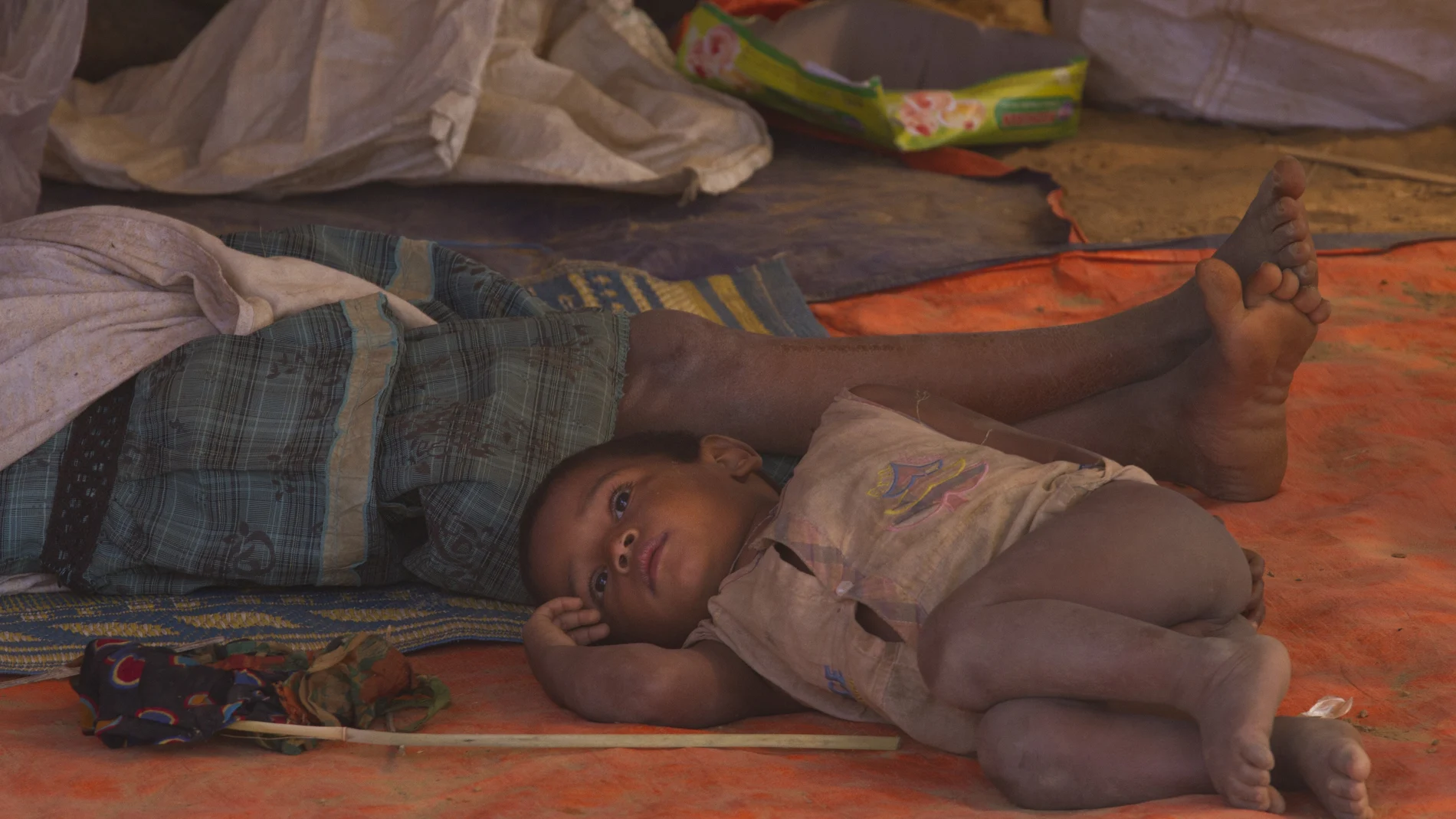 In this Thursday, Jan. 18, 2018, file photo, a newly arrived Rohingya family rests under a temporary shelter at Balukhali refugee camp near Cox's Bazar, Bangladesh. United Nations agencies are warning that more than 350 million people in the Asia-Pacific are going hungry as the coronavirus pandemic destroys jobs and pushes food prices higher. (AP Photo/Manish Swarup, File)