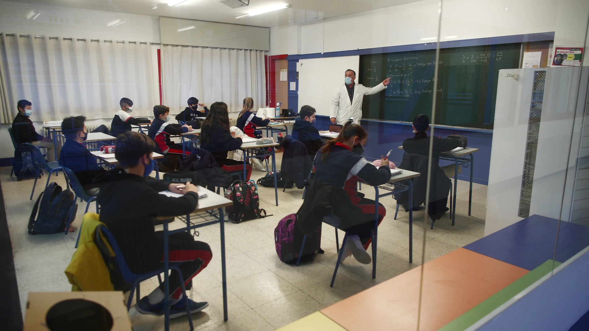 Un profesor imparte clase a los alumnos del colegio Arcangel Rafael el día de la reapertura de los centros educativos tras la gran nevada registrada por el paso de ‘Filomena’, en Aluche, Madrid