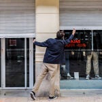 El propietario de un comercio cierra su establecimiento el primer día del cierre total de la hostelería y de tiendas a las 18.00h en Valencia