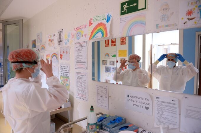 Dos sanitarios se colocan los EPIS momentos antes de entrar en la zona de Urgencias, del Hospital Pío del Rio Hortega de Valladolid