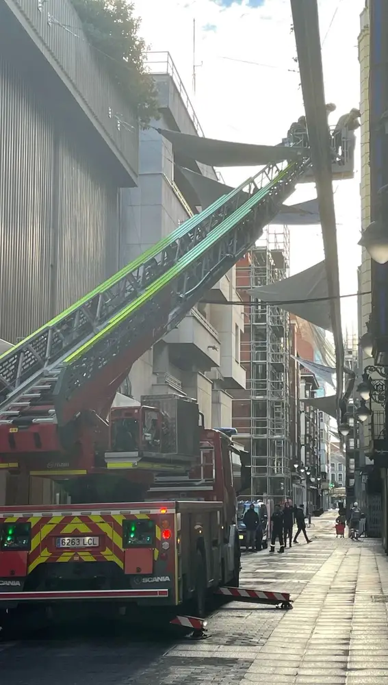 Los bomberos de Valladolid arreglan la lona en la calle Santa María
