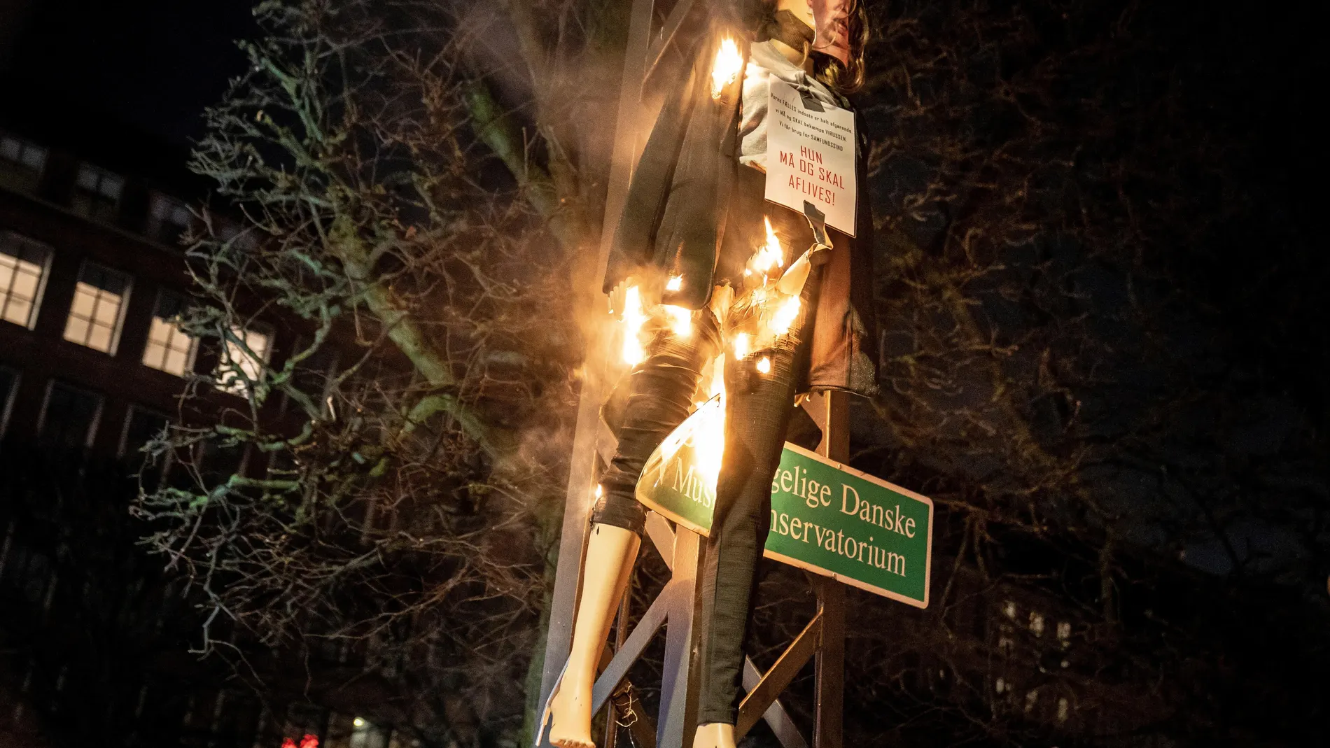 Un maniquí de la primera ministra danesa, Mette Frederiksen, con un cartel al cuello en el que se lee "debe ser colgada", es quemado en una manifestación el pasado sábado