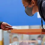 Un hombre muestra su documentación para ejercer su derecho al voto en un colegio electoral de San Sebastián, (País Vasco), el pasado 12 de julio