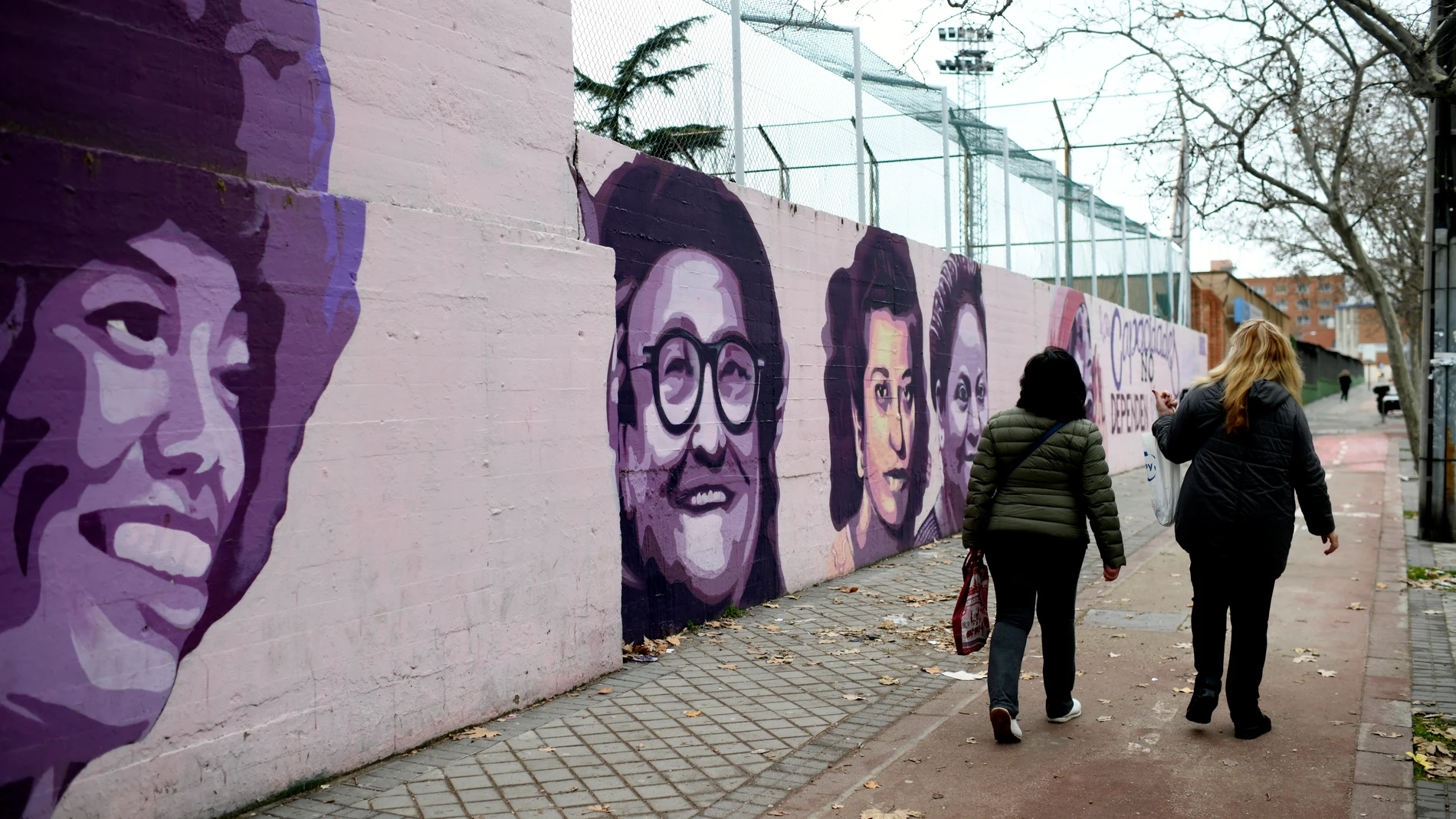 Una mujer pasa por el mural feminista en el polideportivo municipal de la Concepción en el distrito de Ciudad Lineal