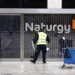 Un operario limpia la cristalera de la sede de Naturgy ubicada en Madrid