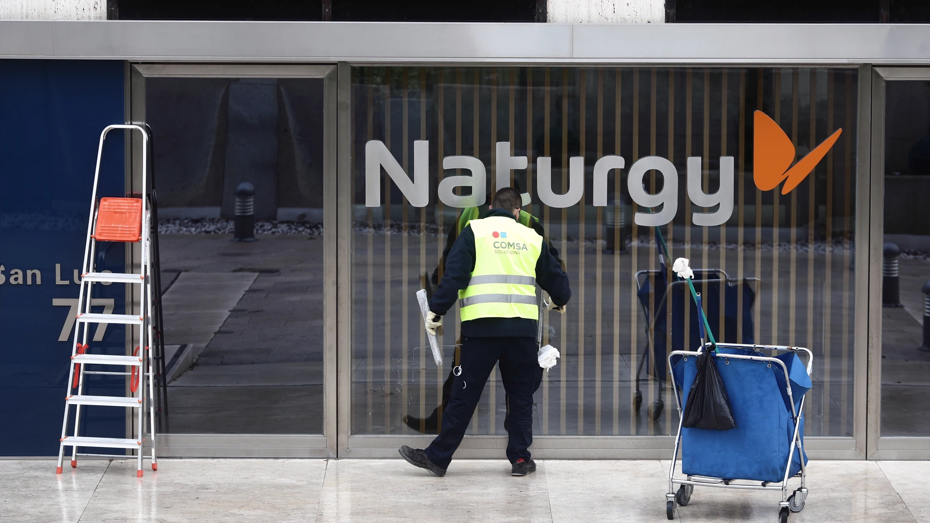 Un operario limpia la cristalera de la sede de Naturgy ubicada en Madrid