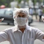 A man wearing a plastic bag as precaution against the coronavirus disease (COVID-19), takes part in protests demanding to reduce the Royal budget and distribute it to people, in front of the government house in Bangkok, Thailand January 26, 2021. REUTERS/Challinee Thirasupa