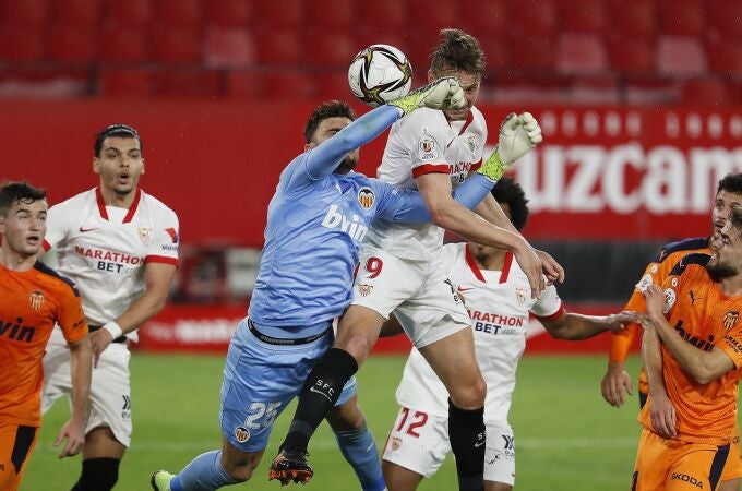El delantero neerlandés del Sevilla Luuk De Jong (c-d) trata de ganar el balón ante la salida del portero Cristian Rivero (c-i), del Valencia