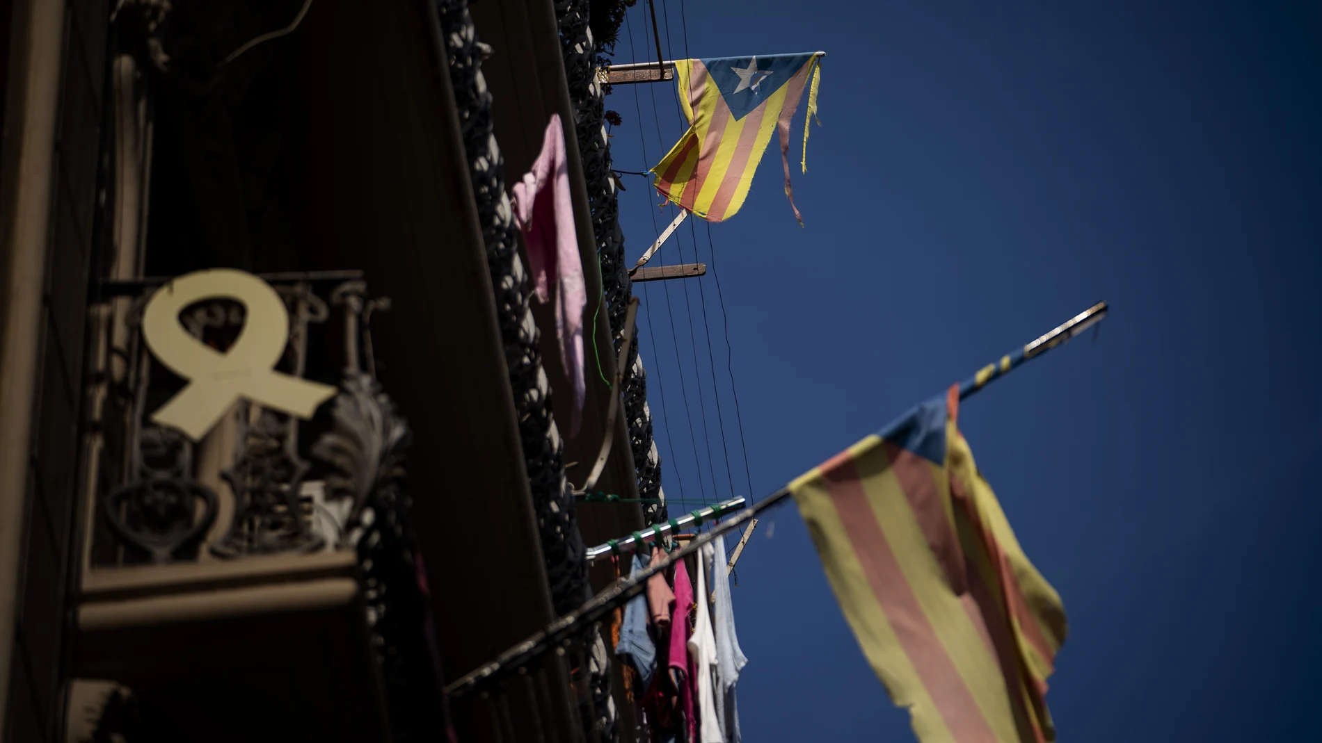 Banderas catalanas y un lazo amarillo en unos balcones de Barcelona
