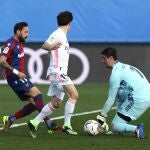 El portero del Real Madrid Thibaut Courtois y el jugador del Levante José Luis Morales, durante el partido de la jornada 21 de LaLiga Santander disputado este sábado en el estadio Alfredo Di Stéfano en Madrid. EFE/Kiko Huesca