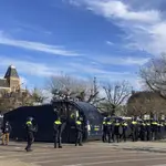 Policías antidisturbios holandeses se alinean frente al Rijksmuseum, atrás a la izquierda, mientras vigilan una manifestación contra el toque de queda y otras restricciones relacionadas con el COVID-19