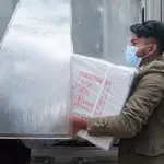 Un trabajador descarga una caja con viales de la vacuna de AstraZeneca en Bangladesh