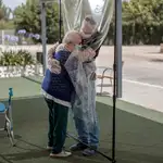 Pilar, de 90 años, abraza a su hijo Manuel a través de un plástico para prevenir la propagación del coronavirus en una residencia de ancianos de Valterna (Valencia). Imagen de archivo.