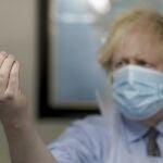 Boris Johnson sostiene un vial con la vacuna del coronavirus