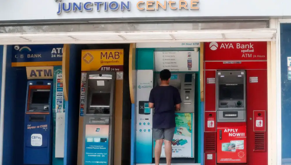Un hombre retira dinero de un cajero en Yangon
