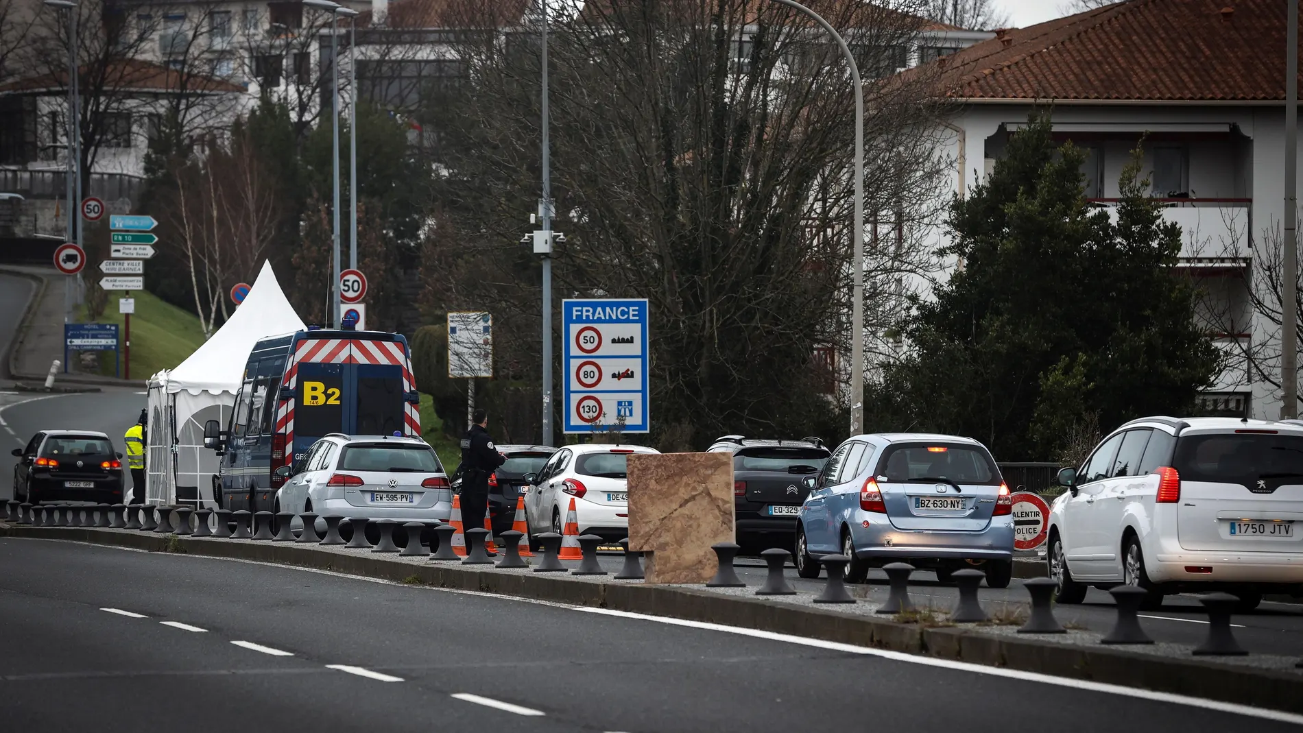 Agentes de la Policía Nacional francesa comprueban los vehículos españoles este lunes en el paso fronterizo entre España y Francia