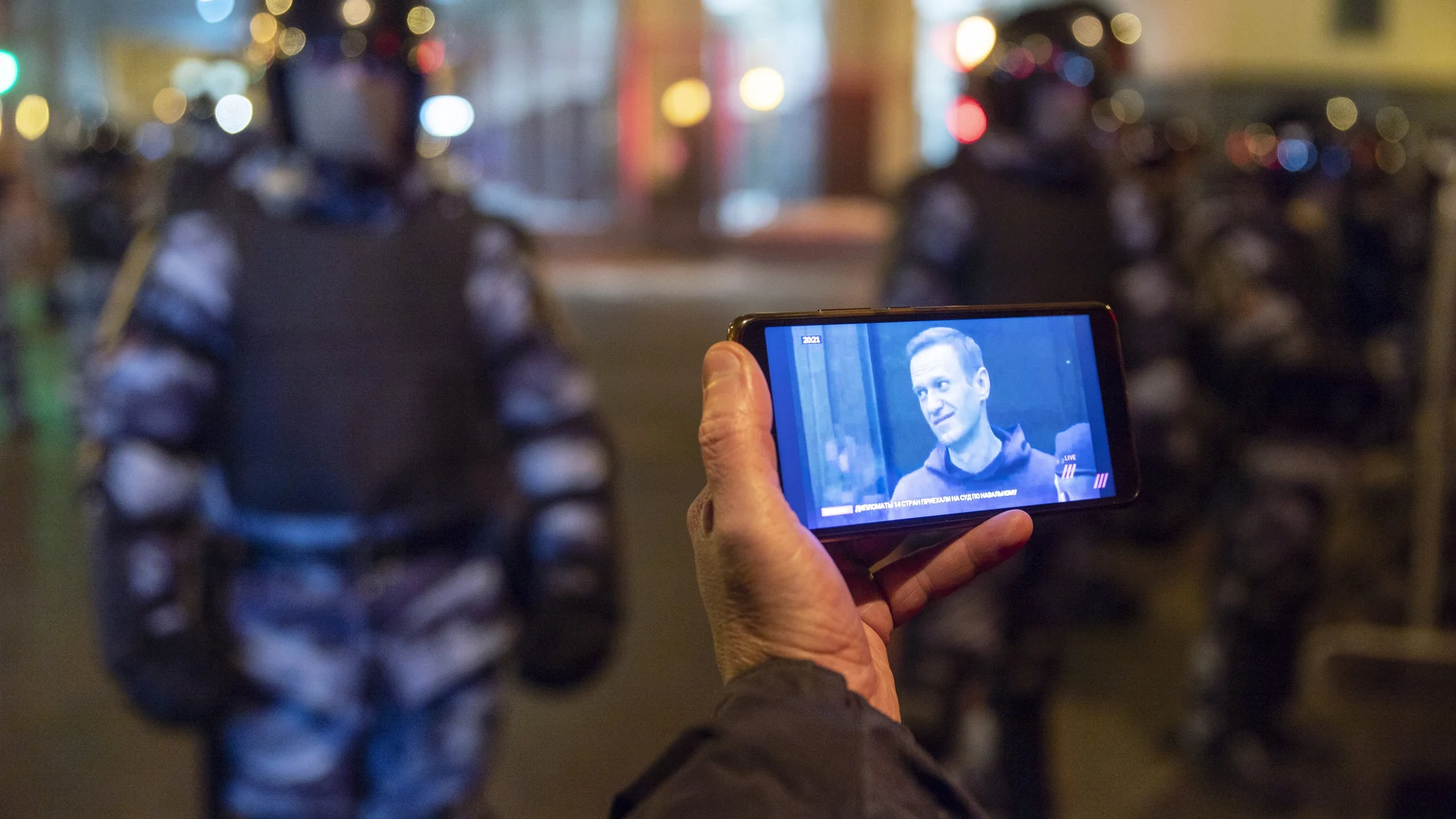 Un periodista sigue la vista judicial contra el líder opositor Alexei Navalni frente a dos agentes armados de la Guardia Nacional
