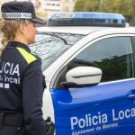 En la imagen, una agente y un coche patrulla de la Policía Local de Manresa