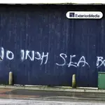 Una mujer pasa frente a un graffiti en el que se puede leer &quot;No a la frontera marítima irlandesa&quot; en el centro de Belfast, Irlanda del Norte