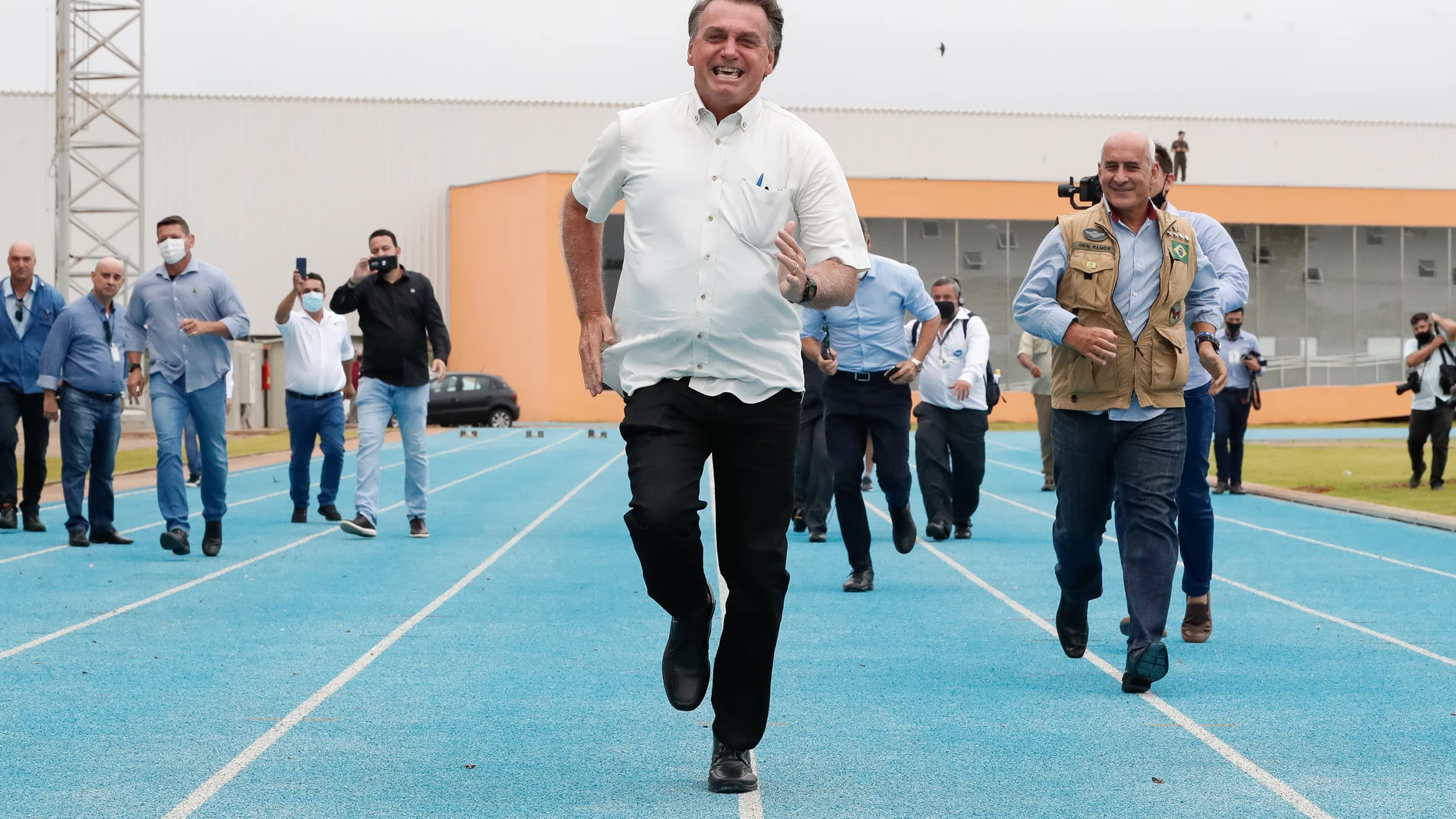 El presidente brasileño, Jair Bolsonaro, participa en una carrera simbólica con otros funcionarios durante su visita al Centro Nacional de Atletismo