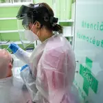 Una trabajadora sanitaria realiza un test de antígeno a un hombre en la farmacia Las Gemelas, Madrid, (España), a 5 de febrero de 2021