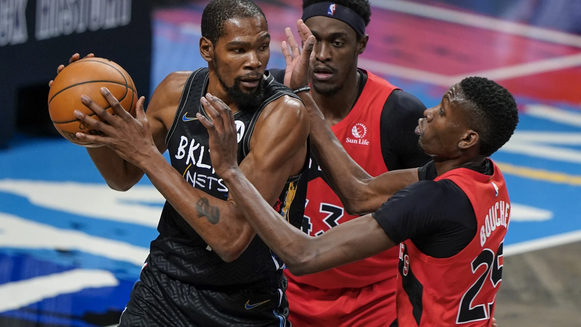 Kevin Durant, defendido por dos jugadores de los Raptors antes de tener que abandonar la cancha por el protocolo sanitario