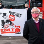 El alcalde de València, Joan Ribó, en una imagen de archivo, durante la presentación de nuevos autobuses híbridos de la EMT. Dos conductores de autobús llevan una pancarta en la que se lee: `Stop privatización de talleres´ de la CGT.