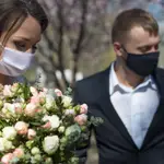 Una pareja de recién casados protegidos con mascarillas durante su boda