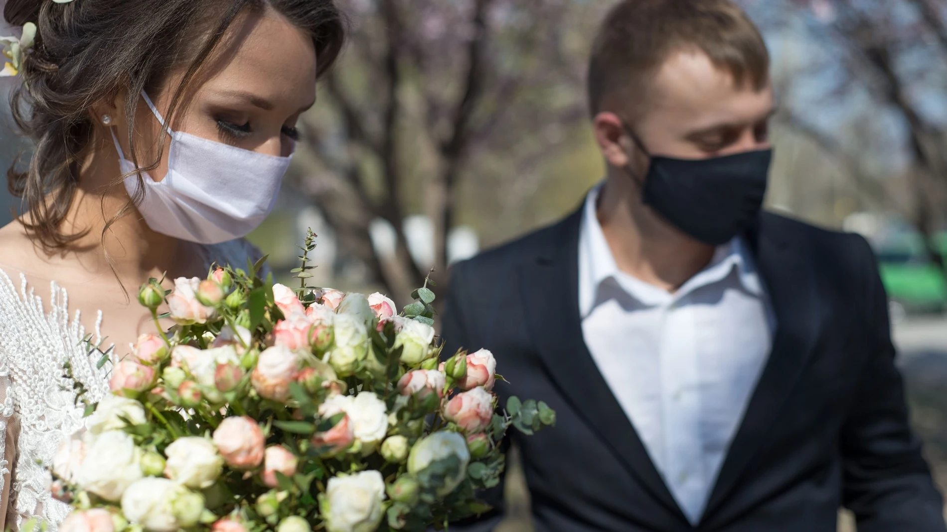 Una pareja de recién casados protegidos con mascarillas durante su boda